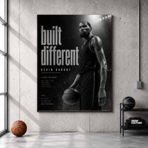 Pode incluir: Um cartaz a preto e branco com Kevin Durant num equipamento de basquetebol a segurar uma bola. O texto diz "built different", "KEVIN DURANT" e inclui citações motivacionais. O cartaz está numa parede de betão com uma bola ao lado.