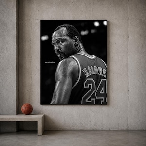 Könnte beinhalten: Ein schwarz-weiß Wandkunstdruck mit einem Porträt des Basketballspielers Karl Malone, der über seine Schulter blickt. Er trägt ein Trikot mit dem Namen MALONE und der Nummer 24 auf dem Rücken. Der Text stay relentless ist links aufgedruckt.