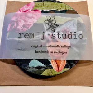 May include: A circular mixed-media collage featuring pink floral and green striped elements, wrapped in a translucent band printed with the text 'rem j studio', 'original mixed-media collage', and 'handmade in michigan' with a flower icon.