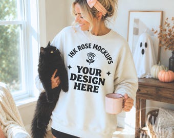 Mockup de moletom Gildan 18000 cor areia, mockup de Halloween com gato preto, mockup de moletom com laço rosa para o outono, mockup de modelo feminina com gola redonda.