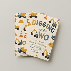 May include: A cream-colored birthday invitation card featuring a construction theme with illustrations of yellow excavators, dump trucks, orange traffic cones, and hard hats. The text reads DIGGING INTO TWO, join us to celebrate mason's 2nd birthday.