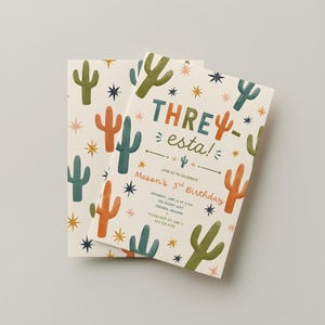 May include: A rectangular birthday invitation card featuring a cream background with a pattern of green and orange cacti and dark blue stars. The text reads THREesta! Join us to celebrate Mason's 3rd Birthday, Saturday, June 1st at 3 PM, 123 Desert Way, Phoenix, Arizona, please RSVP to Jane 555.123.4567.