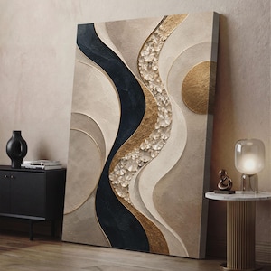 May include: A rectangular canvas wall art piece featuring a textured abstract composition. The design includes flowing, curved lines in shades of cream, beige, and deep black, accented by a vertical strip of metallic gold leaf and circular gold elements.