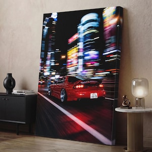 May include: A vertical canvas print featuring a red sports car driving on a city street at night. The background shows blurred neon lights and tall buildings. The car has a rear spoiler, silver wheels, and a licence plate reading 48-98.