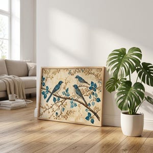 Peut inclure: Une impression d'art encadrée rectangulaire représentant trois oiseaux bleus perchés sur une branche d'arbre brune avec des feuilles bleues sur un fond beige. L'œuvre est insérée dans un cadre en bois clair et présente une illustration détaillée.