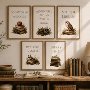May include: Five framed wall art prints with light wood frames, each featuring a cream background, dark text, and illustrations of books. The text reads: Bookworms Welcome, Adventure Begins With A Book, School Library, Reading Is Magic, Library Time.
