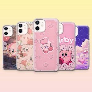 May include: Five clear smartphone cases featuring various pixel art designs of the pink character Kirby. The designs include Kirby with hearts, Kirby with an umbrella in a purple sky, and a pattern of multiple Kirby faces with various items.