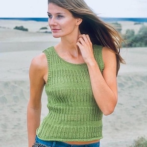 Puede incluir: Una camiseta sin mangas de punto color verde lima con textura acanalada y paneles verticales, cuello redondo y dobladillo recto, combinada con pantalones vaqueros azules adornados con un cinturón de cadena de metal oscuro en la cintura.