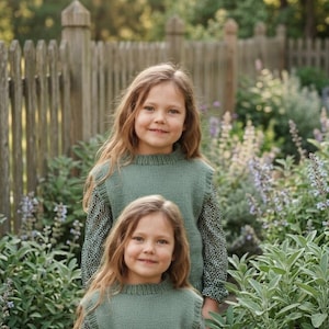 Könnte beinhalten: Zwei passende salbeigrüne Strickwesten über dunkelgrünen Langarmshirts mit kleinem weißem Blumenmuster. Die Strickwesten haben einen gerippten Rundhalsausschnitt und gerippte Armausschnitte und sind in einer einfachen Strickstruktur gefertigt.