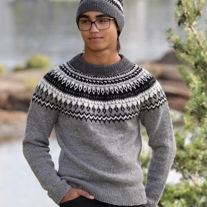 Puede incluir: Un suéter gris de manga larga y un gorro a juego, ambos con un patrón circular en el canesú con diseños geométricos en negro, blanco y gris oscuro. El suéter tiene un cuello redondo, puños y dobladillo acanalados, y el gorro tiene un borde.