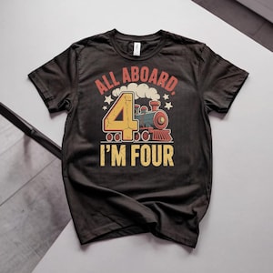 May include: A black short-sleeved t-shirt featuring a graphic print of a steam locomotive train and the text "ALL ABOARD" and "I'M FOUR" in yellow and red. The design includes a large yellow number four and white steam clouds.