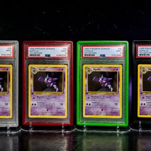 Könnte beinhalten: Vier bewertete 1999 Pokemon Alpollo Sammelkarten in silbernen, roten, grünen und schwarzen Schutzhüllen. Jede Karte zeigt den violetten Geist-Charakter Alpollo mit gelben Rändern, Text und einem KP-Wert von 50 in durchsichtigen Hüllen.