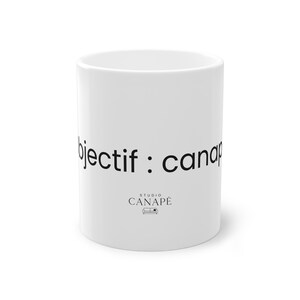 Peut inclure: Mug en céramique blanche avec l'inscription noire "objectif : canapé" et le logo "Studio Canapé". Le mug est de forme cylindrique, avec un design épuré, parfait pour les boissons chaudes.