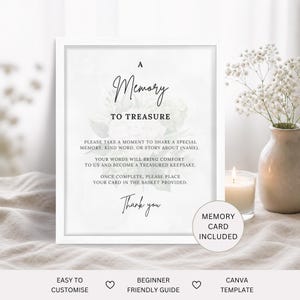 May include: A framed sign with the text "A Memory to Treasure." The sign includes instructions for sharing a memory and a "Memory Card Included" label. A vase of white flowers and a lit candle are in the background.