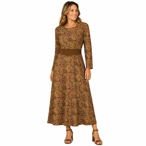 May include: A long-sleeved maxi dress featuring a brown and gold paisley pattern throughout. The garment includes a solid brown wide waistband, a round neckline, and a floor-length skirt that flares slightly from the waist down to the hemline.