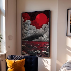 May include: A framed rectangular wall art print featuring a stylized mountain peak surrounded by voluminous grey clouds, a large solid red sun, and dark red ocean waves with white foam crests, displayed in a black frame on a white wall.