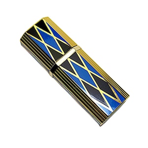 Puede incluir: Un estuche rectangular de metal dorado con un diseño geométrico. El estuche presenta formas de diamantes negros, azules y blancos. El diseño está acentuado con rayas negras y doradas. El estuche es rectangular y tiene una abertura con bisagras.