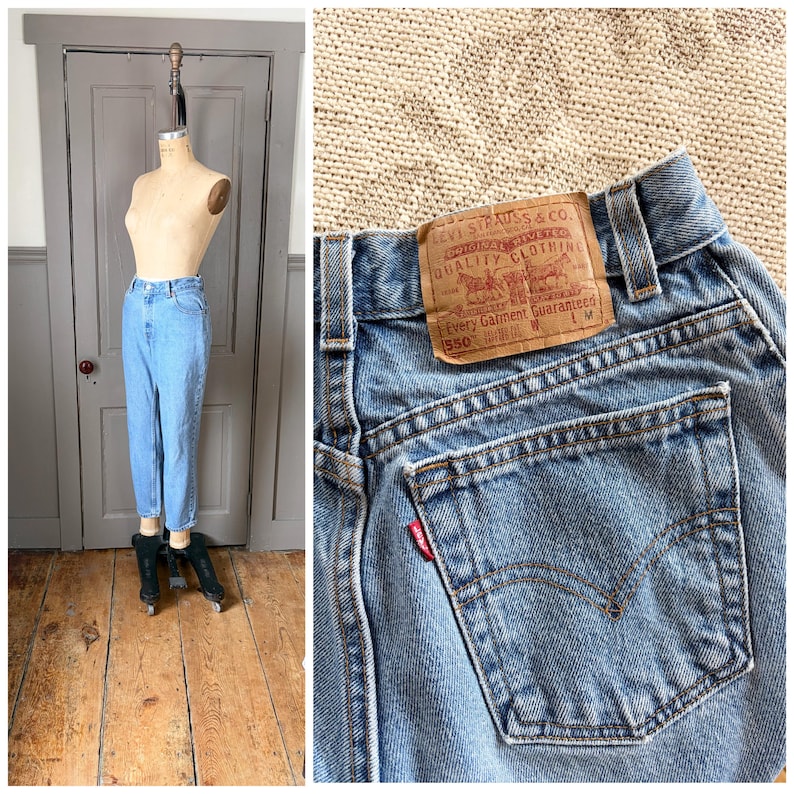May include: Light blue denim jeans displayed on a mannequin. The jeans have a classic fit and are cuffed at the ankles. A close-up shows the back pocket with a red Levi's tag and a brown leather label.