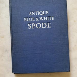 May include: A hardcover book with a dark blue cover. The title "ANTIQUE BLUE & WHITE SPODE" is printed in white, centered on the cover. The book appears to be in good condition.