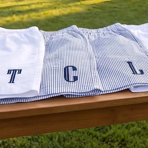 May include: A set of three ceramic mugs with a speckled, matte finish. The mugs are in shades of cream, light gray, and dark gray. Each mug has a simple, minimalist design, perfect for coffee or tea.