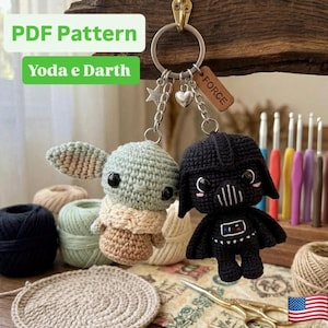 Puede incluir: Un llavero de metal con dos figuras de ganchillo, una de color verde claro y beige y otra negra, unidas a una anilla con un pequeño dije de corazón, una estrella y una etiqueta de madera grabada con la palabra FORCE.