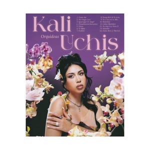 May include: A music album cover featuring Kali Uchis with the title Orquideas in purple text. The artist is surrounded by white and yellow orchids. A tracklist is printed in the upper right corner. The artist wears a necklace and rings.