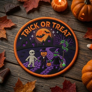 May include: A round embroidered patch featuring a Halloween scene with a mummy, a pumpkin-headed figure in a suit, and a witch on a purple path. The text TRICK OR TREAT is arched at the top above a full moon, bats, and a dark house silhouette.
