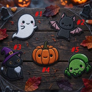 May include: Five embroidered patches featuring Halloween themes: a white ghost, a black bat with pink wings, a black cat wearing a purple witch hat, an orange pumpkin, and a green spider. Each patch is numbered from one to five in red text.