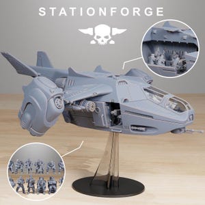 May include: A gray resin model of a futuristic dropship aircraft with a clear cockpit, mounted on a black stand. The text STATIONFORGE appears at the top. Two circular insets show the interior cabin with seated figures and a group of standing figures.