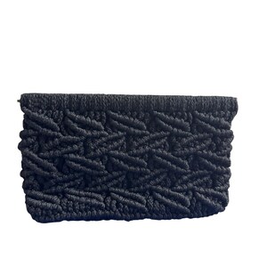 May include: A rectangular clutch bag crafted from black cord in a macrame style. The exterior features a repeating diagonal knot pattern across the entire surface, with a solid, straight top edge and a slightly rounded bottom edge construction.