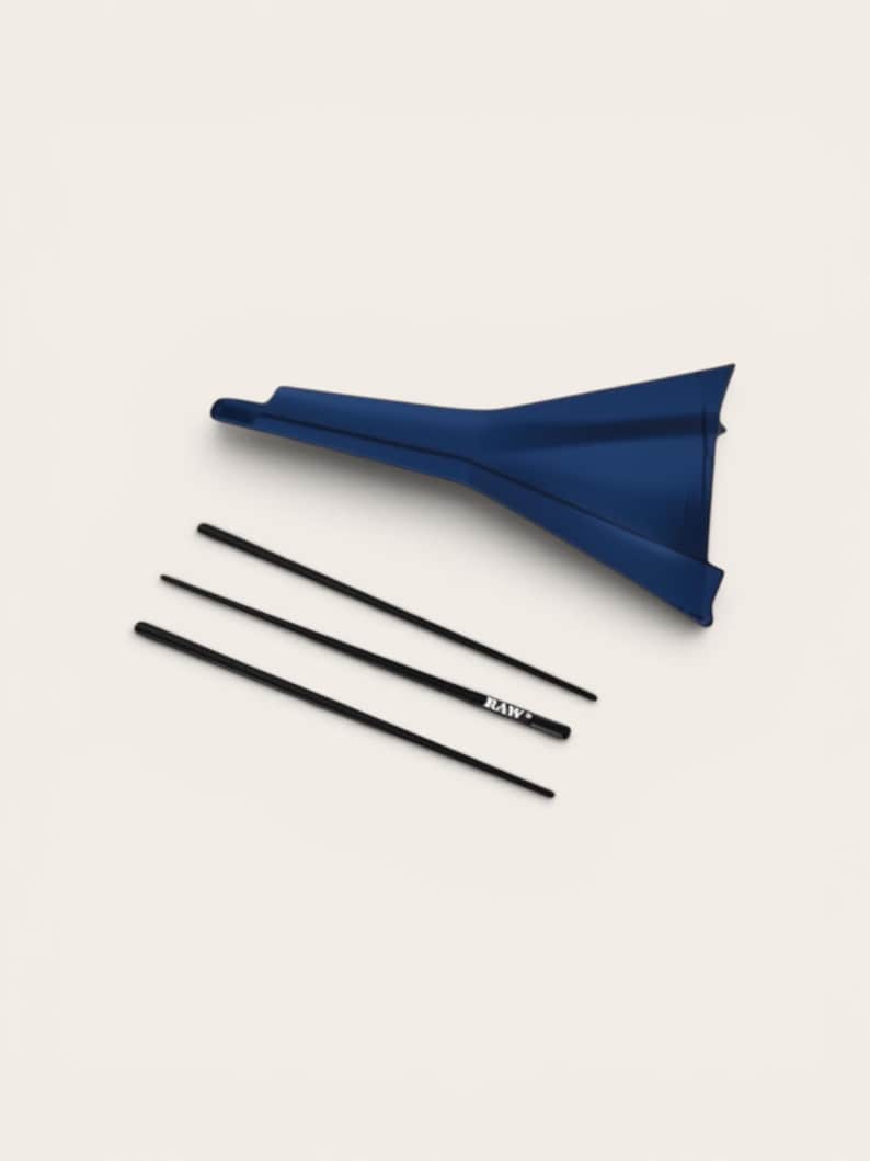May include: A dark blue funnel positioned above three thin black sticks. One of the sticks features the white text "RAW" printed on its surface. The items are arranged separately against a plain, light-coloured background.