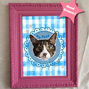 May include: A framed cat portrait with a pink frame. The artwork features a cat's face in a blue circle with the name "Mr. Bean". The background is a blue and white gingham pattern, with a pink star-shaped tag that says "Hand Drawn:)".