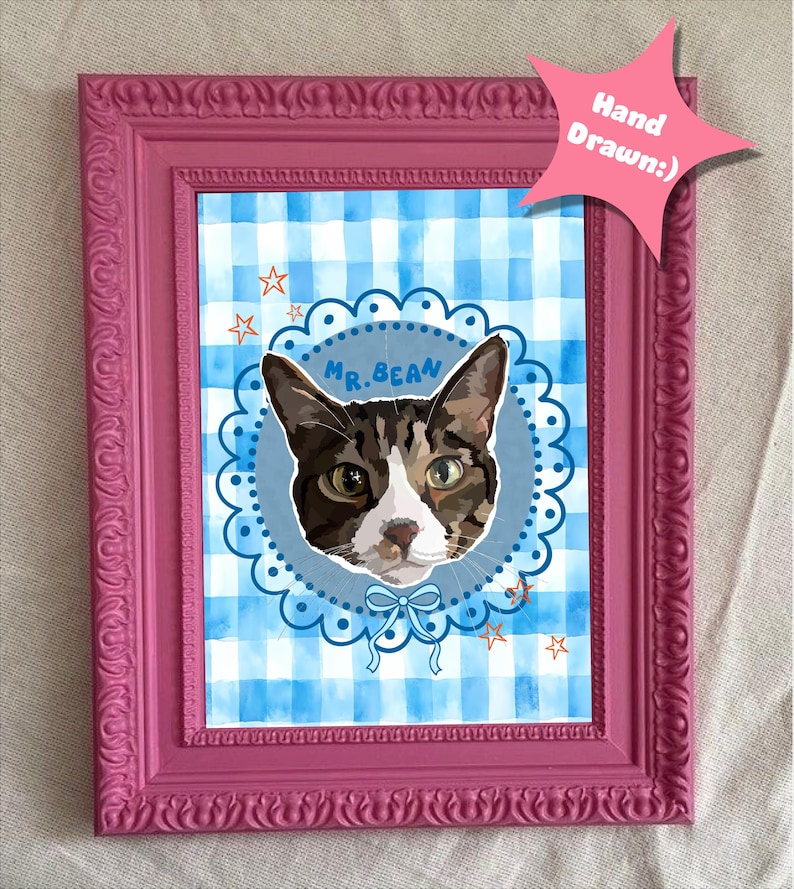 May include: A framed cat portrait with a pink frame. The artwork features a cat's face in a blue circle with the name "Mr. Bean". The background is a blue and white gingham pattern, with a pink star-shaped tag that says "Hand Drawn:)".