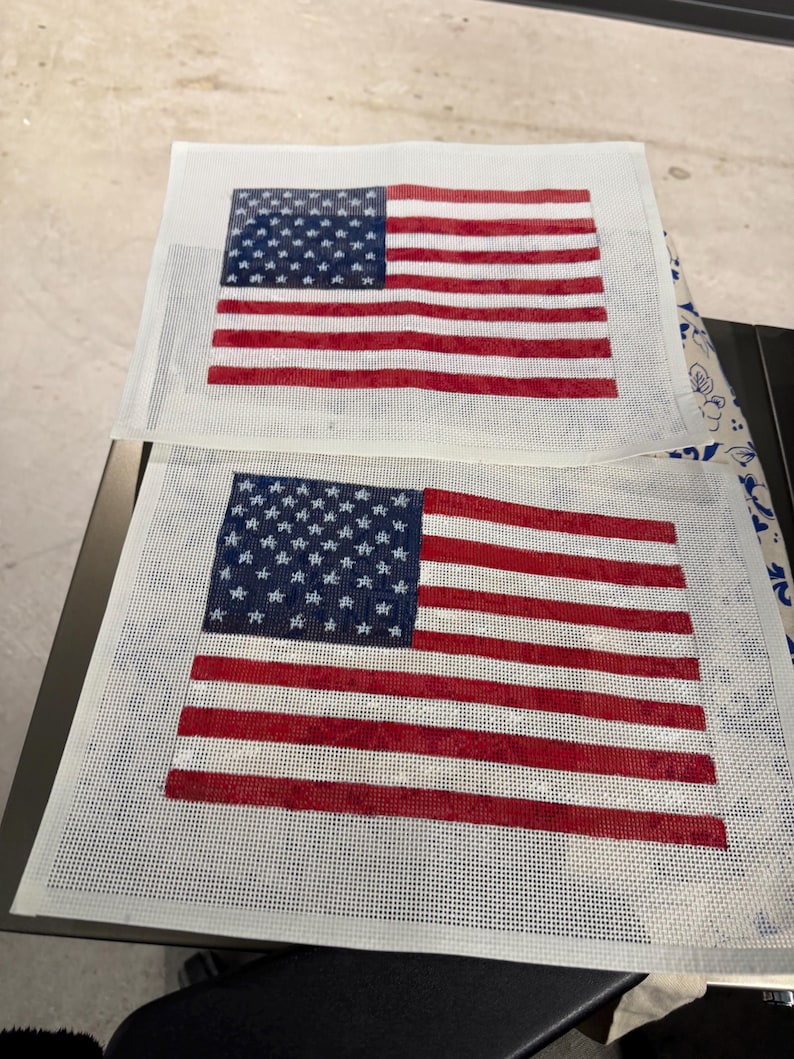 May include: Two rectangular needlepoint canvases featuring the American flag design. Each canvas displays a blue field with white stars in the upper left corner and alternating horizontal red and white stripes across the remaining surface area.