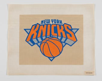 Może przedstawiać: Kwadratowe płótno do haftu z logo drużyny koszykarskiej New York Knicks w kolorach pomarańczowym, niebieskim i szarym. Wzór zawiera napis NEW YORK KNICKS nad grafiką piłki do koszykówki. Płótno ma wzór w kratkę i etykietę 18 MESH.