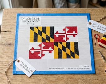Może przedstawiać: Kwadratowe płótno do haftu z wzorem flagi Maryland w kolorach czerwonym, białym, czarnym i żółtym. Płótno zawiera tekst Taylor & Kobi Needlepoint, 13-mesh, Maryland Flag, wzór 18 cm x 15 cm oraz numer przedmiotu #MD001, z nożyczkami i nicią.