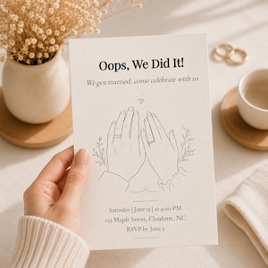 May include: A rectangular wedding invitation card with off-white paper featuring black text that reads Oops, We Did It! We got married, come celebrate with us. Below is a line drawing of two hands wearing rings, with event details for June 15.