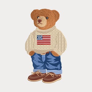 May include: An embroidered patch of a brown teddy bear wearing a cream-colored cable knit sweater with a red, white, and blue American flag graphic, blue denim jeans with a brown belt, and brown leather boat shoes with tan laces.