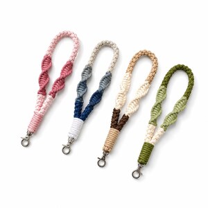 Puede incluir: Cuatro correas de muñeca de macramé con diseño de cuerda trenzada. Cada correa está hecha de cuerda de algodón de dos tonos en combinaciones de rosa, azul y gris, marrón y crema, y verde y crema, terminadas con un cierre de metal plateado.