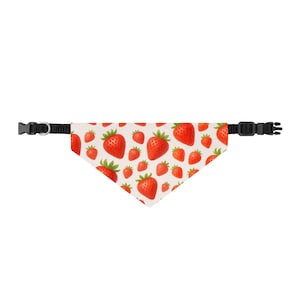 Può includere: Una bandana triangolare per animali domestici con un motivo ripetuto di fragole rosse con foglie verdi su sfondo color crema chiaro. La bandana è fissata a un collare in nylon nero regolabile con fibbia in plastica nera e anello a D in metallo.