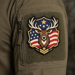 May include: A tactical patch featuring a brown deer head with large antlers centered on a shield-shaped design. The background displays the American flag with red and white stripes and a blue field with white stars. A gold star and chevron are below.