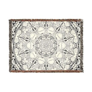 Peut inclure: Un plaid tiss&eacute; rectangulaire pr&eacute;sentant un motif complexe inspir&eacute; d'un mandala en noir et blanc. Le design se compose de formes g&eacute;om&eacute;triques sym&eacute;triques et de lignes fines rayonnant depuis un point central, avec des bords &agrave; franges.