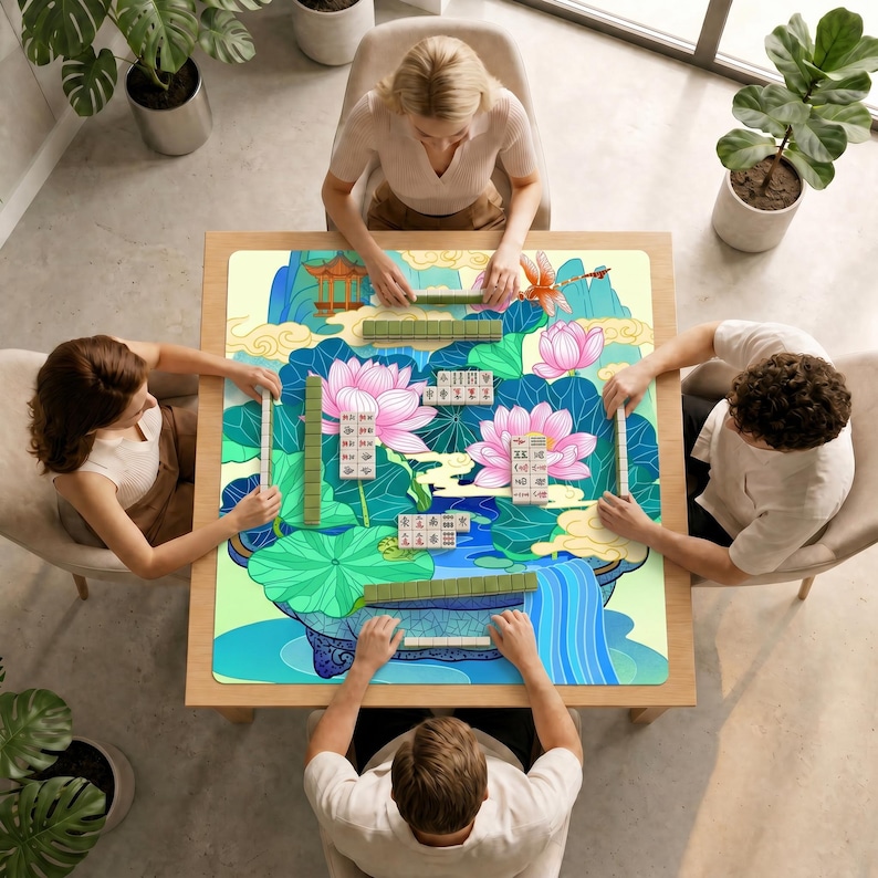 High angle view of four people seated around a square table playing mahjong on the lotus pond mat in a bright room with several green plants.