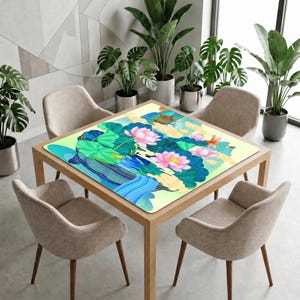 Lotus pond game mat on a square table in a modern room, showing the waterfall edge of the illustration flowing toward the viewer.
