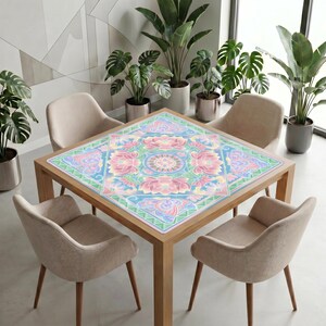 Modern dining area with neutral chairs and potted plants, featuring a wooden table covered by the pastel lotus mahjong table mat as a decorative centerpiece.