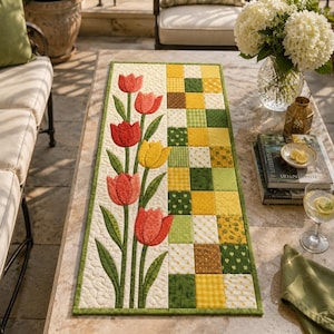 May include: A rectangular table runner featuring a quilted design with a vertical row of red and yellow tulip appliqués on a cream background, alongside a patchwork section of alternating green and yellow squares with various patterns.