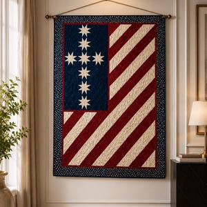 May include: A rectangular wall hanging quilt featuring a dark blue field with a cross pattern of eight-pointed white stars. The remaining area consists of diagonal red and cream stripes. The entire piece is framed by a dark blue border with white dots.