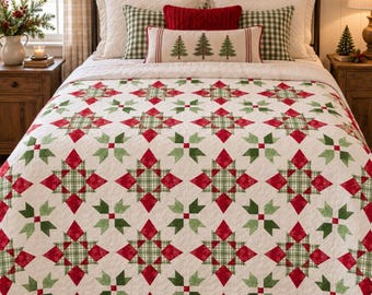 May include: A bed quilt featuring a repeating star pattern in red and green on a white background. The quilt is layered over a bed with white pillows, green and white checkered pillows, a red textured pillow, and a long lumbar pillow with trees.