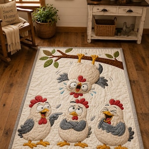 May include: A rectangular quilted rug featuring an off-white background with a gray border. The design displays four cartoon chickens: one hanging upside down from a brown tree branch, and three standing below, each with distinct expressions.