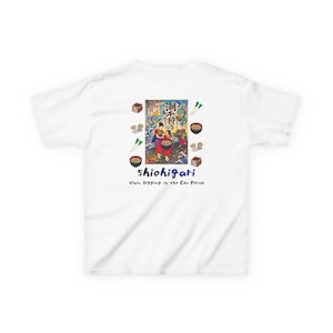 以下が含まれることがあります： 背面にカラフルなグラフィックがプリントされた白いTシャツ。デザインには、日本語のテキスト、お椀、野菜と共に潮干狩りをする人々の様子が描かれています。イラストの下には「shiohigari Clam Digging in the Edo Period」というテキストが記されています。